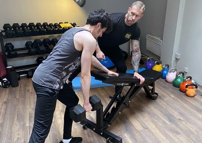 Steve helping Mehmet with his single arm bent over row